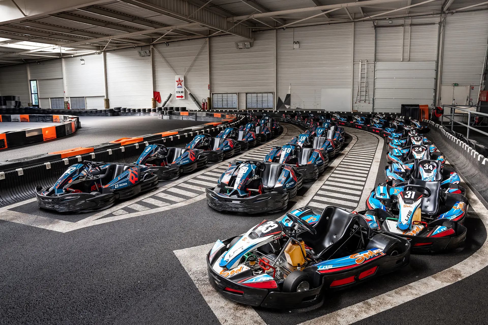Piste de karting indoor moderne avec virages relevés et éclairage dynamique