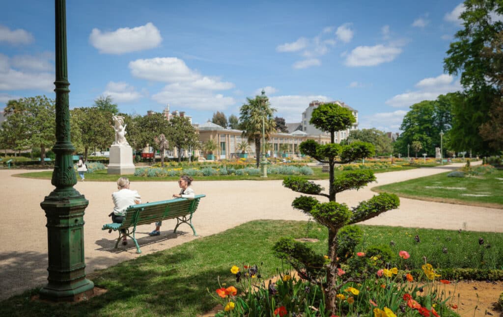 Magnifique jardin français avec roseraie, fontaine et promeneurs par une journée ensoleillée à Rennes